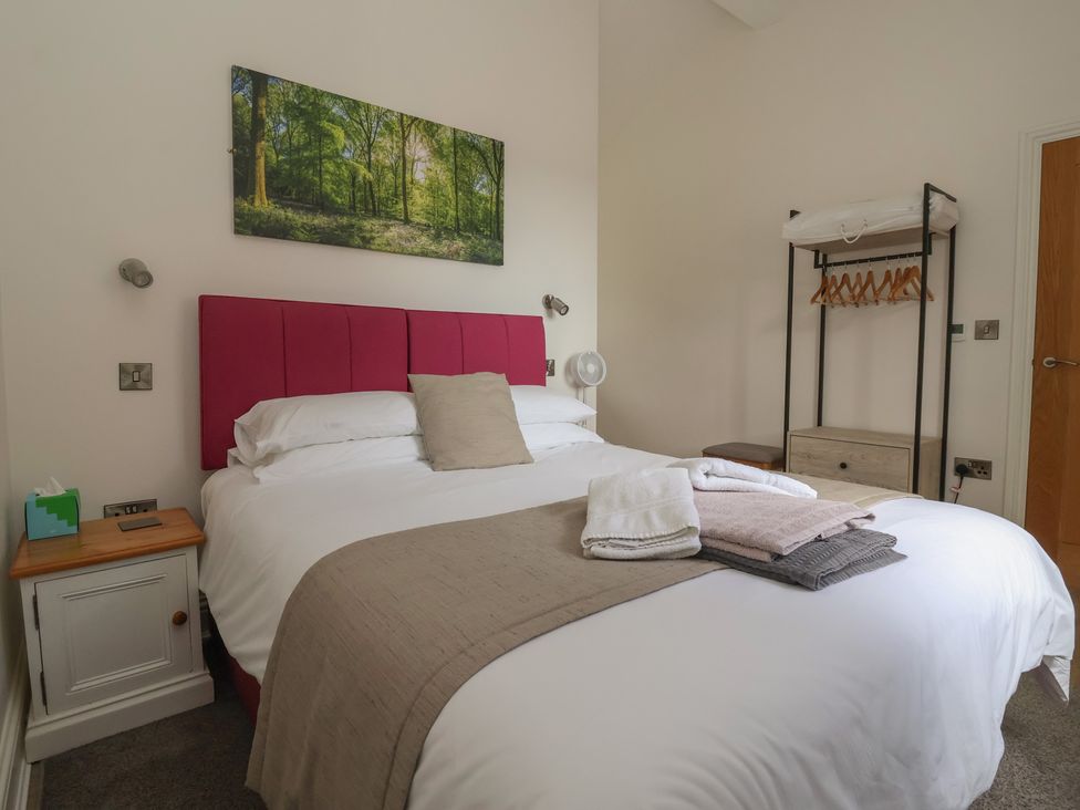 A bedroom with a bed and wooden furniture at Shepherd's Crook in Follifoot near Spofforth