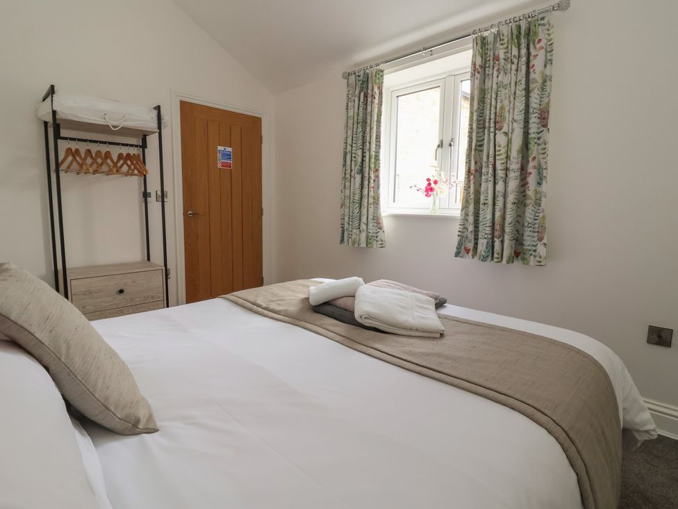A bedroom with a bed and wardrobe at Shepherd's Crook in Follifoot near Spofforth