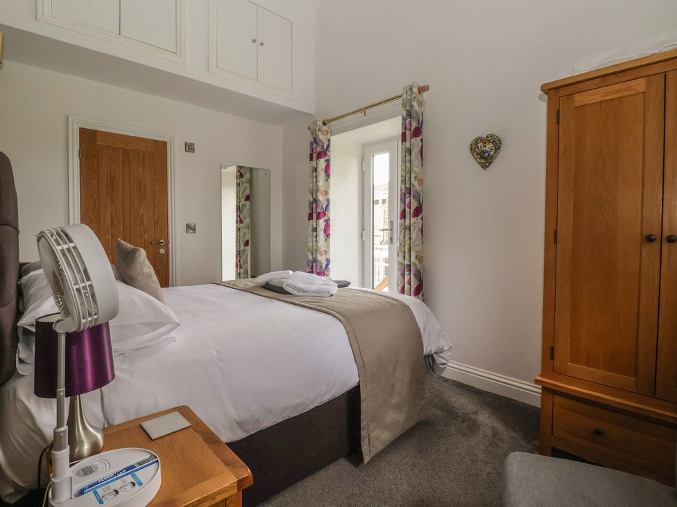 A bedroom with a bed and wardrobe at Shepherd's Crook in Follifoot near Spofforth