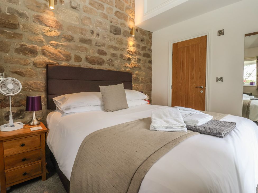 A bedroom with a double bed and bedside table at Shepherd's Crook in Follifoot near Spofforth