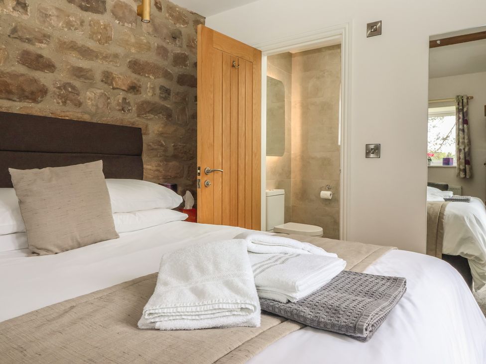 A bedroom with a bed and towels at Shepherd's Crook in Follifoot near Spofforth