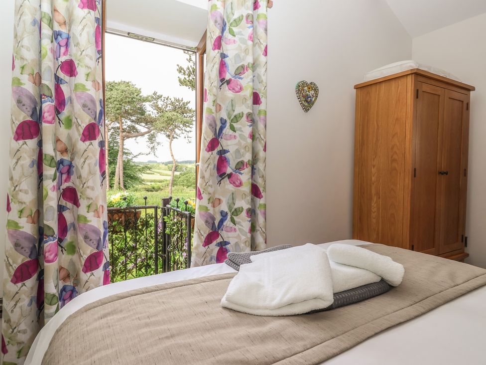 A bedroom with open window and wardrobe at Shepherd's Crook in Follifoot near Spofforth