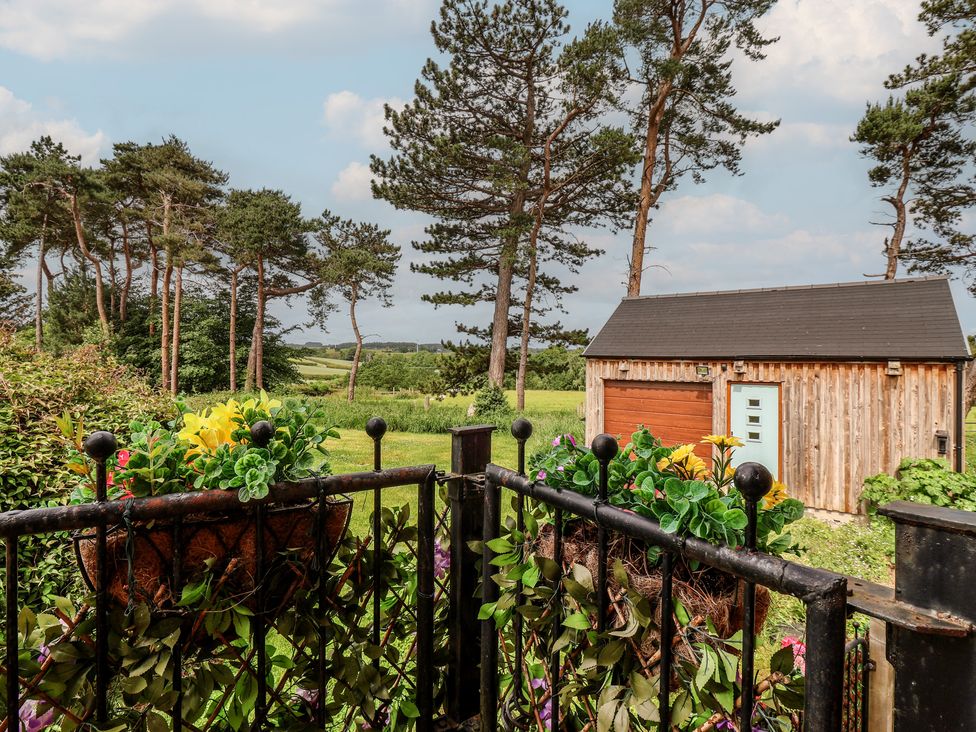 An outdoor area with a shed and flowers at Shepherd's Crook in Follifoot near Spofforth