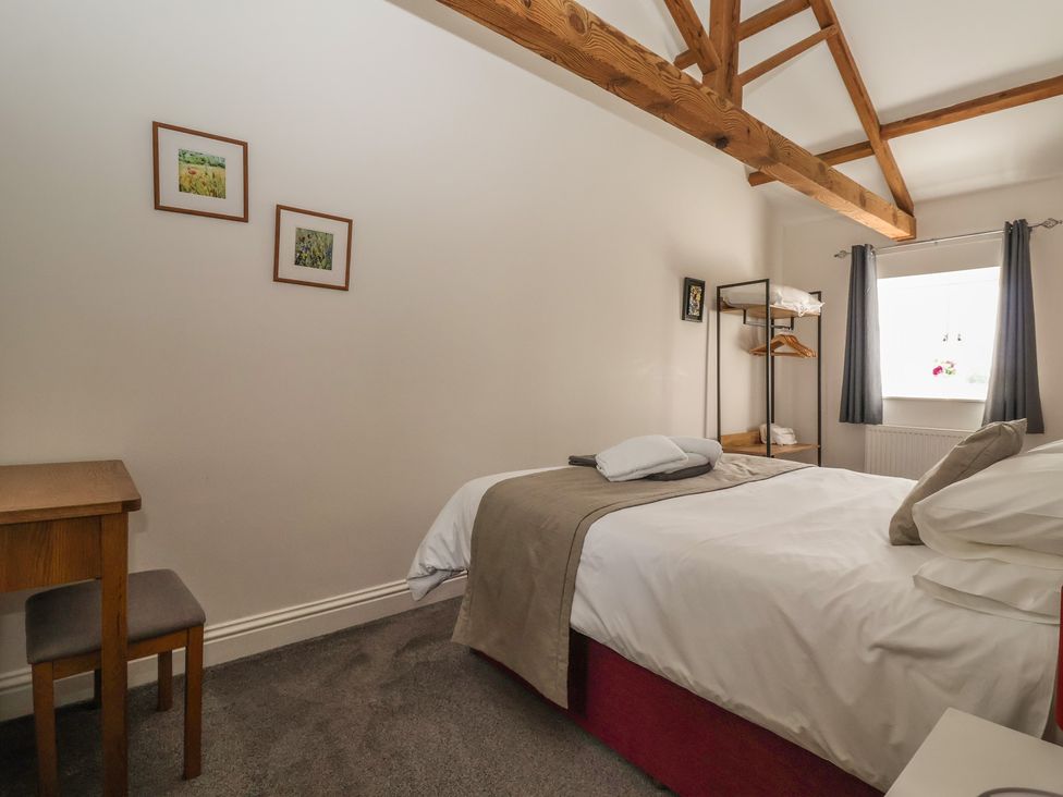 A bedroom with a bed and a table at Shepherd's Crook in Follifoot near Spofforth