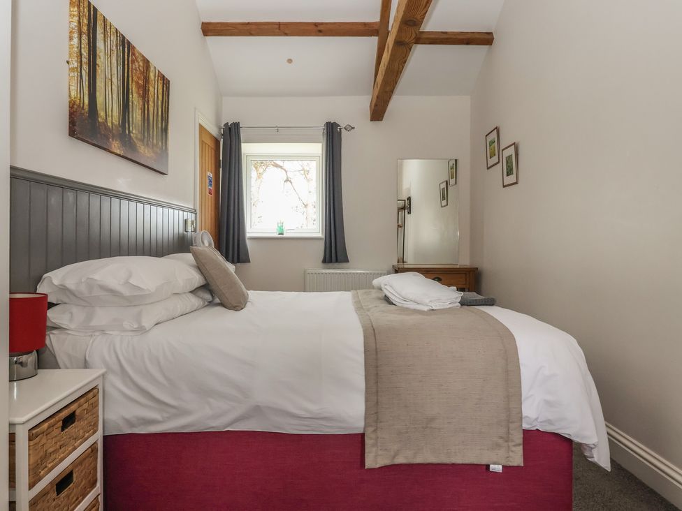 A bedroom with a bed and window at Shepherd's Crook in Follifoot near Spofforth