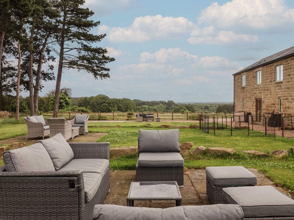 An outdoor seating area with a garden view at Shepherd's Crook in Follifoot near Spofforth