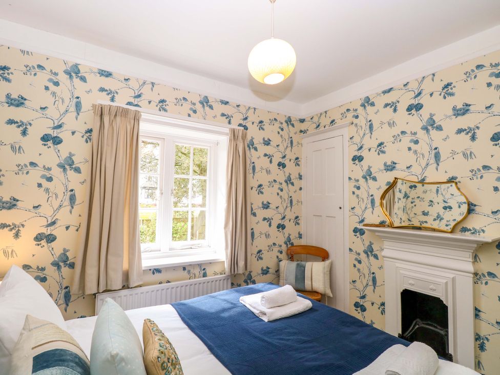 A bedroom with a bed and a window at Beckhythe Cottage Overstrand