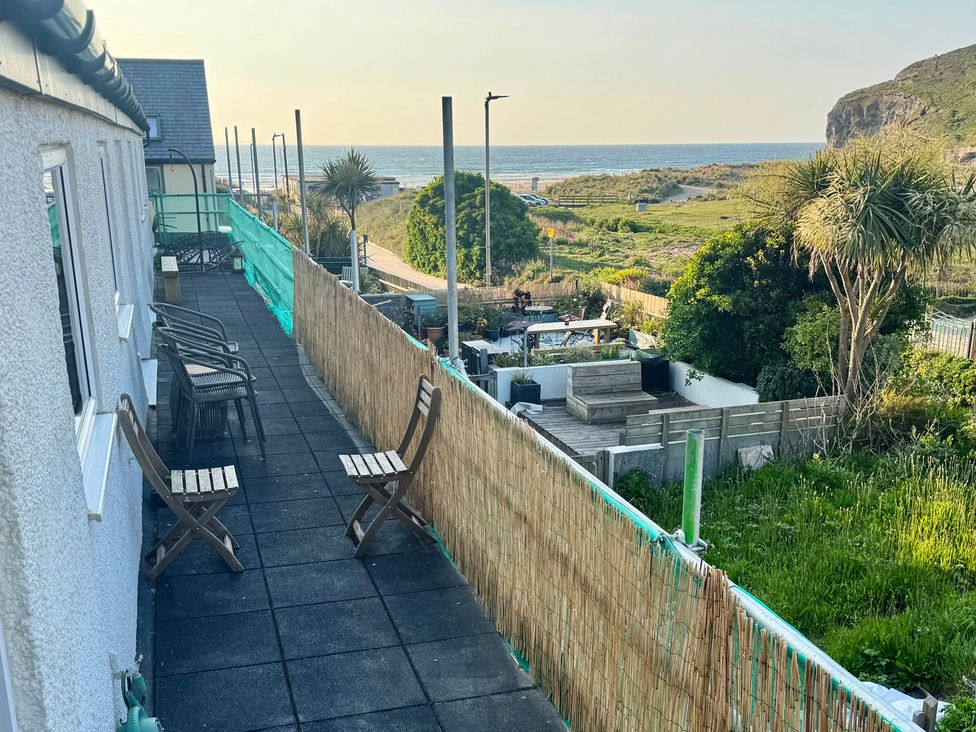 An outdoor area with chairs and a view of the sea at Gecko Beach in Porthtowan