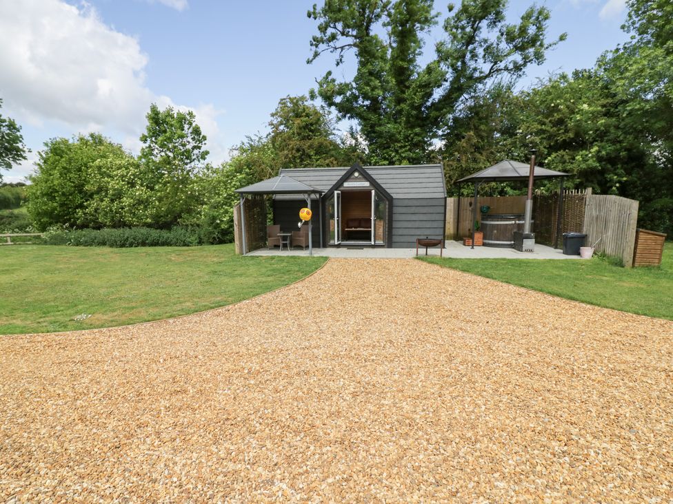 An outdoor area with a shed and seating at Acorn Lodge At Bridge Lake Farm & Fishery, Chacombe