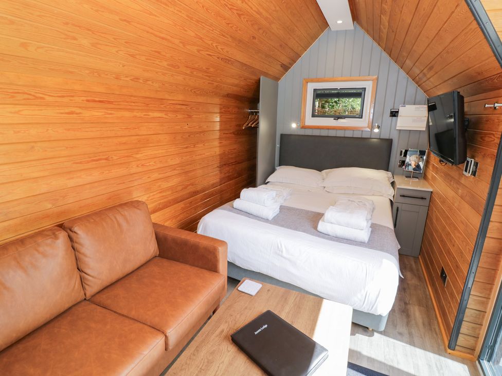 A bedroom with a bed and sofa at Acorn Lodge At Bridge Lake Farm & Fishery Chacombe