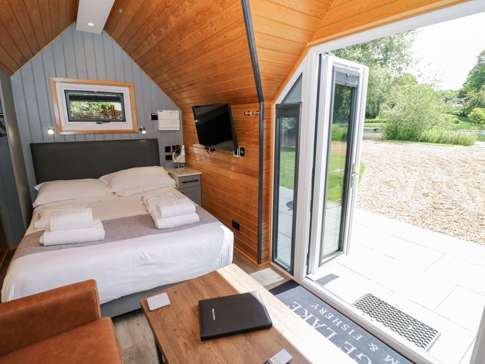 A bedroom with a bed and television at Acorn Lodge At Bridge Lake Farm & Fishery, Chacombe