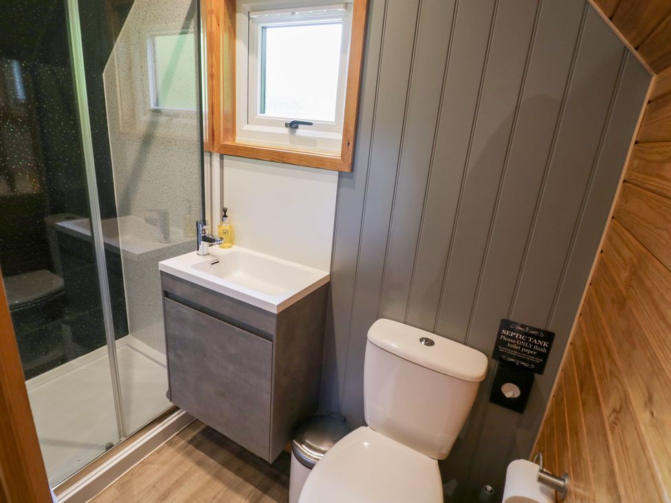 A bathroom with a toilet, sink, and shower at Acorn Lodge At Bridge Lake Farm & Fishery, Chacombe
