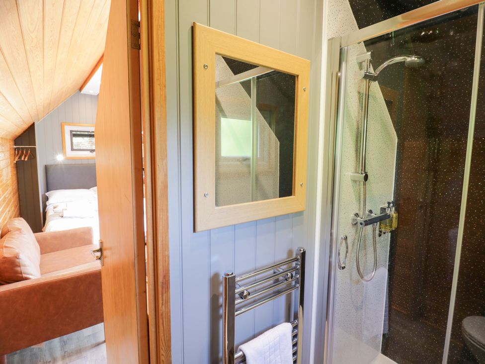 A bathroom with a shower and towel rail at Acorn Lodge At Bridge Lake Farm & Fishery, Chacombe