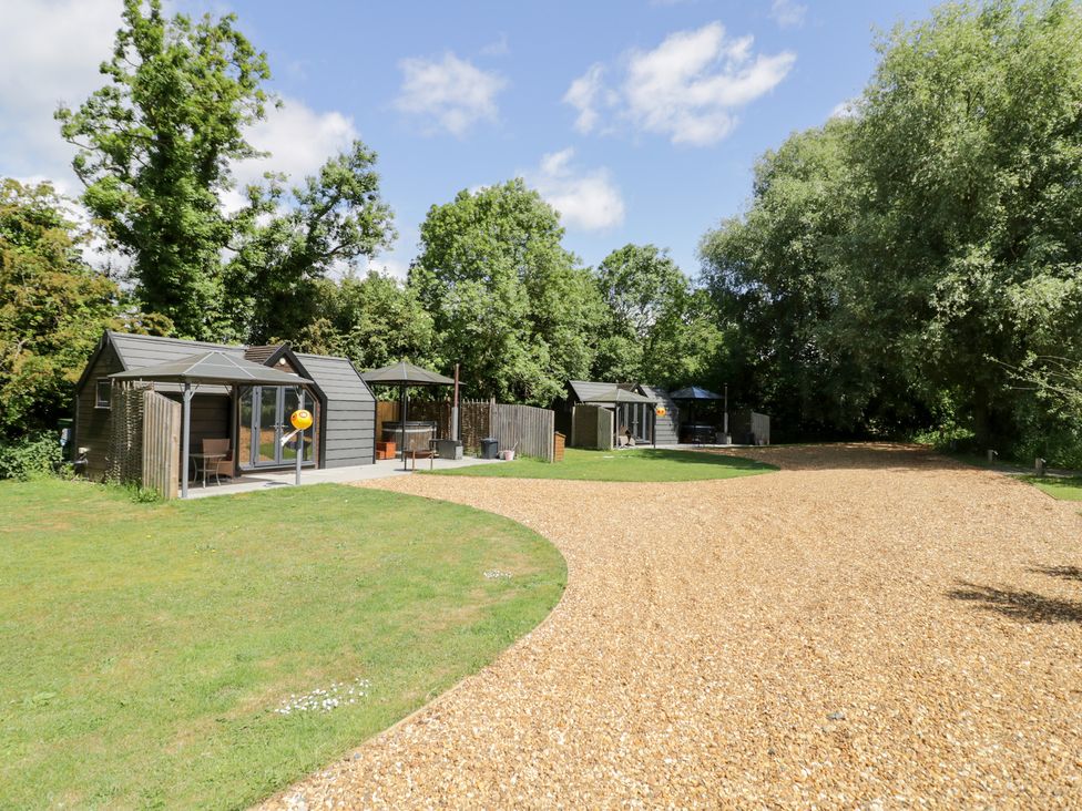 An outdoor area with cabins and a gravel path at Acorn Lodge At Bridge Lake Farm & Fishery in Chacombe