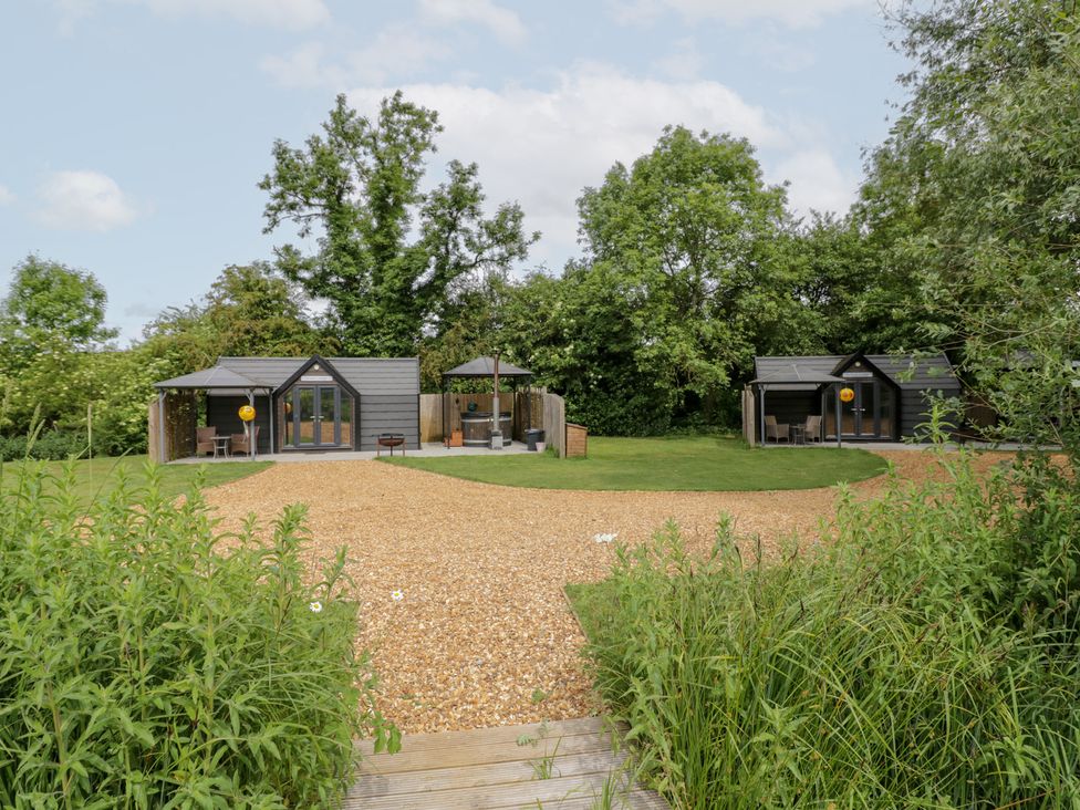 An outdoor area with cabins and a gravel path at Acorn Lodge At Bridge Lake Farm & Fishery in Chacombe