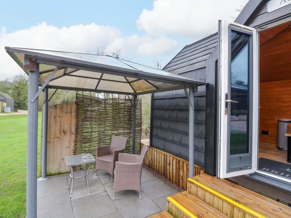 An outdoor seating area with a gazebo and table at Acorn Lodge At Bridge Lake Farm & Fishery, Chacombe