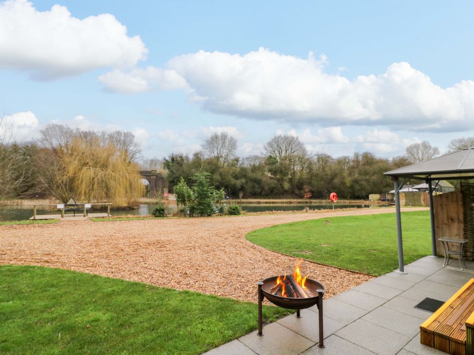 An outdoor area with a fire pit and bench at Acorn Lodge At Bridge Lake Farm & Fishery Chacombe