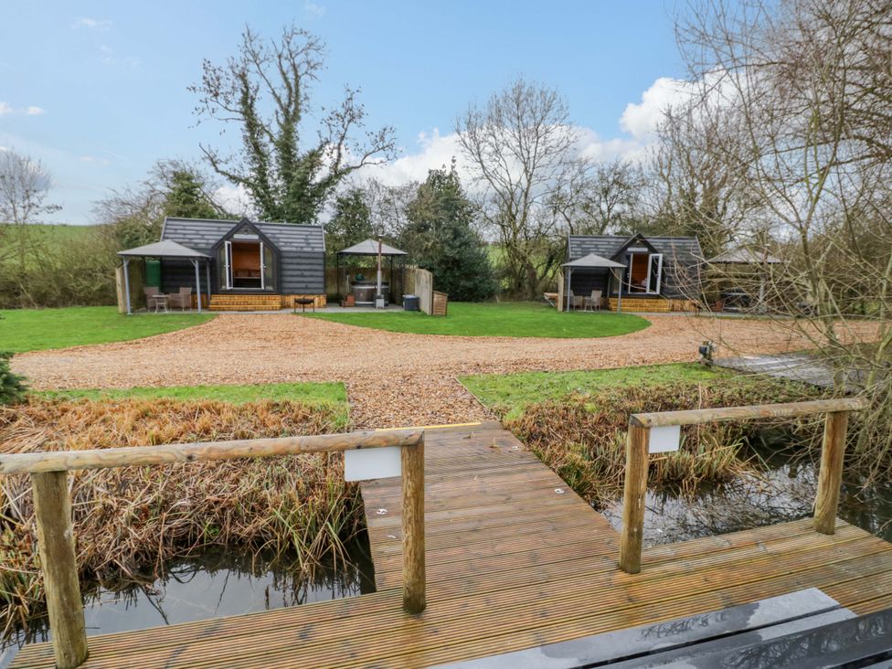 An outdoor area with cabins and a pathway at Acorn Lodge At Bridge Lake Farm & Fishery Chacombe