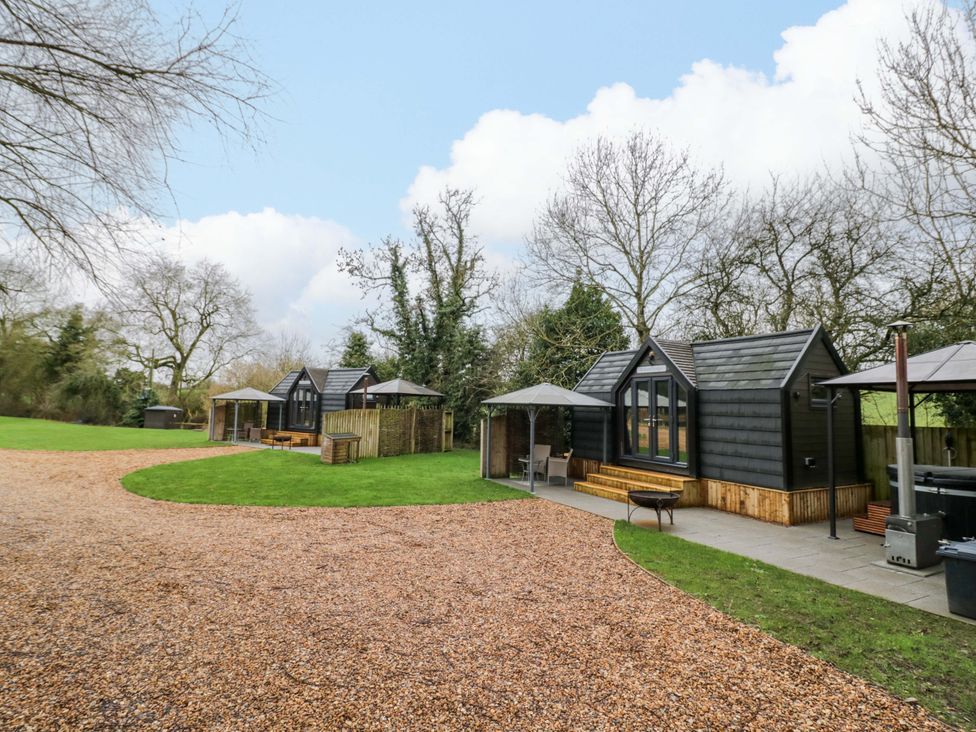 Three cabins with outdoor seating at Acorn Lodge At Bridge Lake Farm & Fishery Chacombe