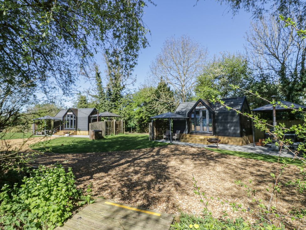 An outdoor area with several cabins and a deck at Acorn Lodge At Bridge Lake Farm & Fishery, Chacombe
