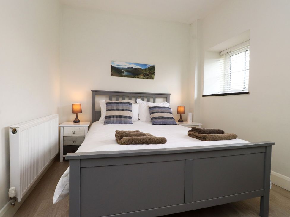 A bedroom with a bed and bedside table at Pen Y Cefn in Pen Y Cefn
