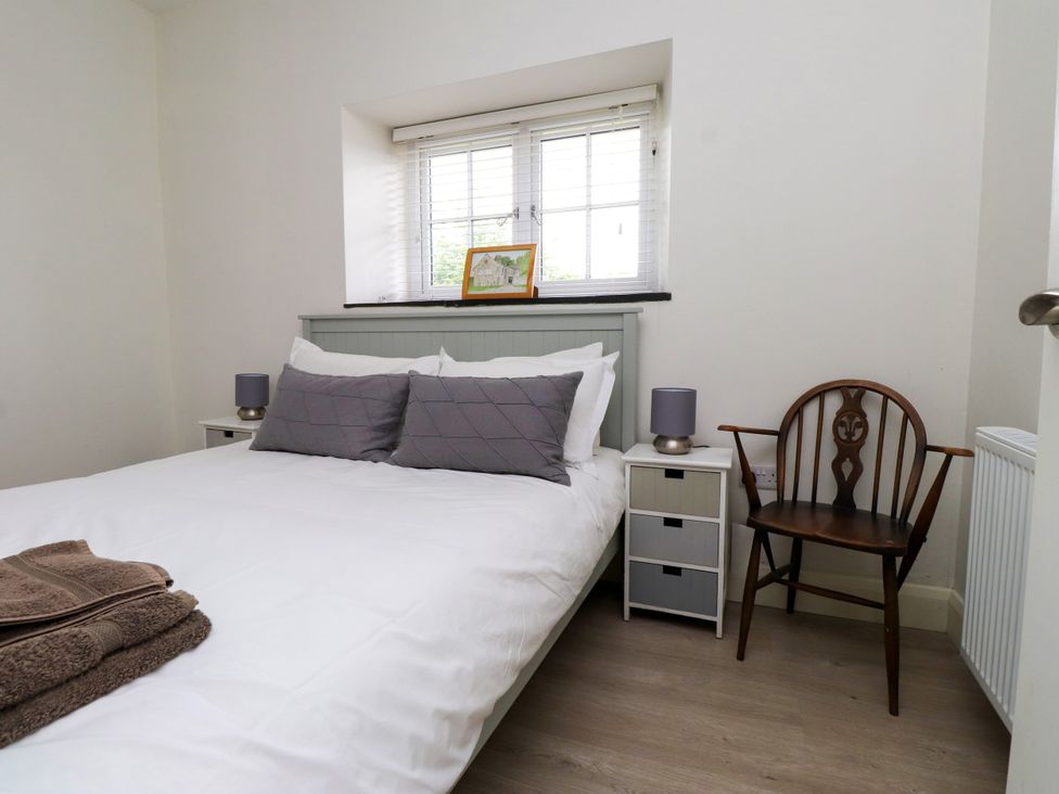 A bedroom with a bed and chair at Pen Y Cefn in Pen Y Cefn