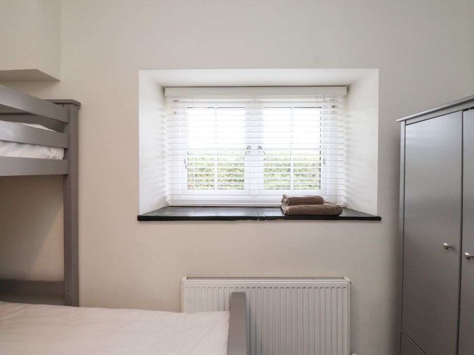 A bedroom with a bunk bed and window at Pen Y Cefn