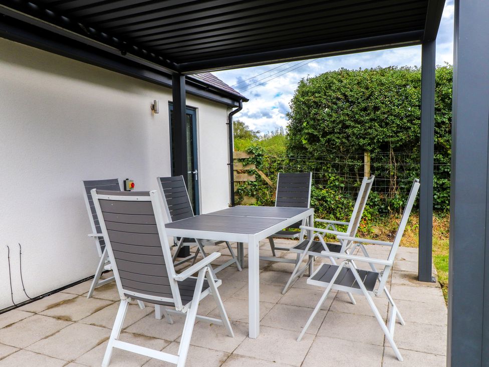 An outdoor dining area with a table and six chairs at Pen Y Cefn