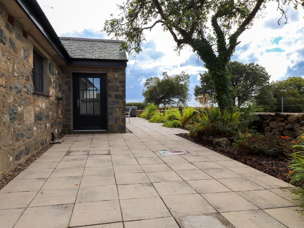 An outdoor area with a stone wall and plants at Pen Y Cefn in Pen Y Cefn