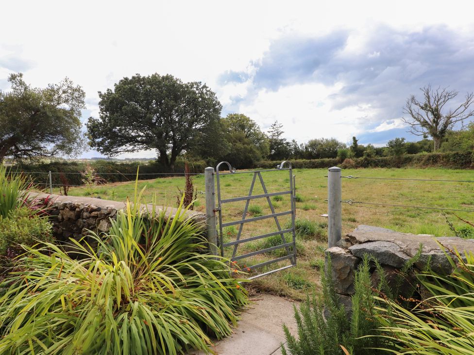 An outdoor area with a gate leading to a grassy field at Pen Y Cefn in Pen Y Cefn