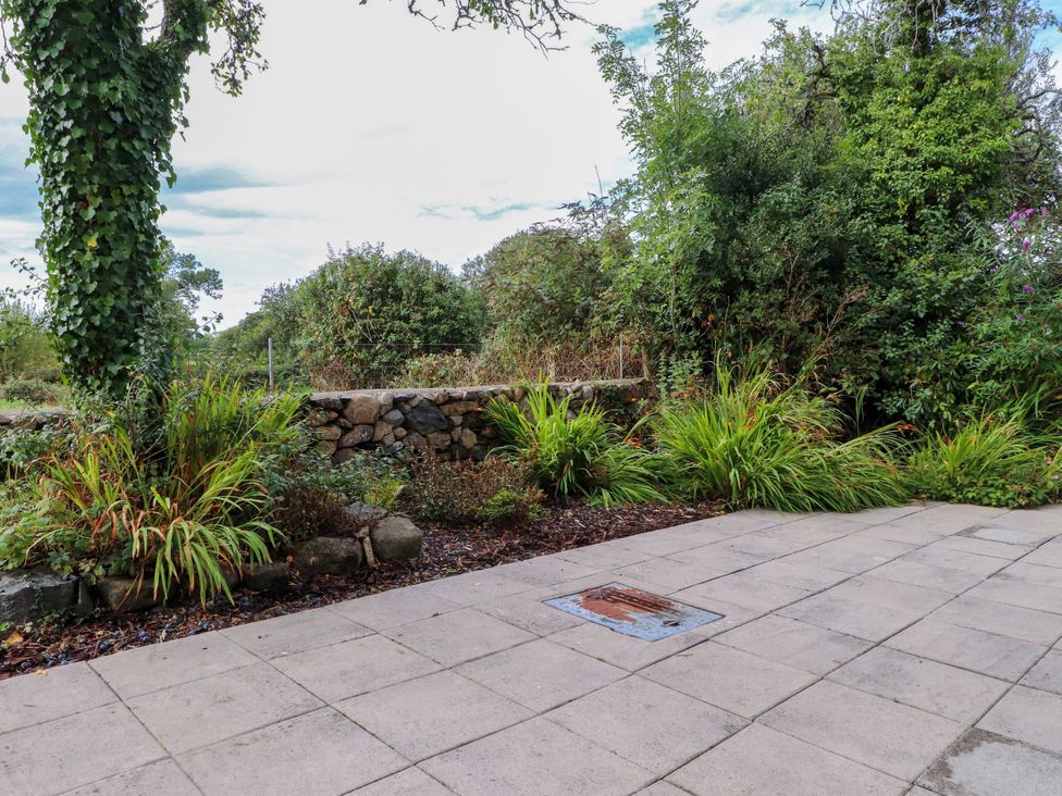 A garden with a stone wall and plants at Pen Y Cefn