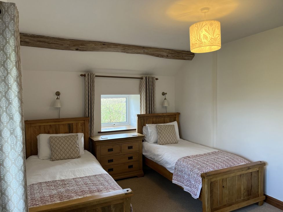 A bedroom with two beds and a window at The Stables At Cae Gwyn in Ruthin