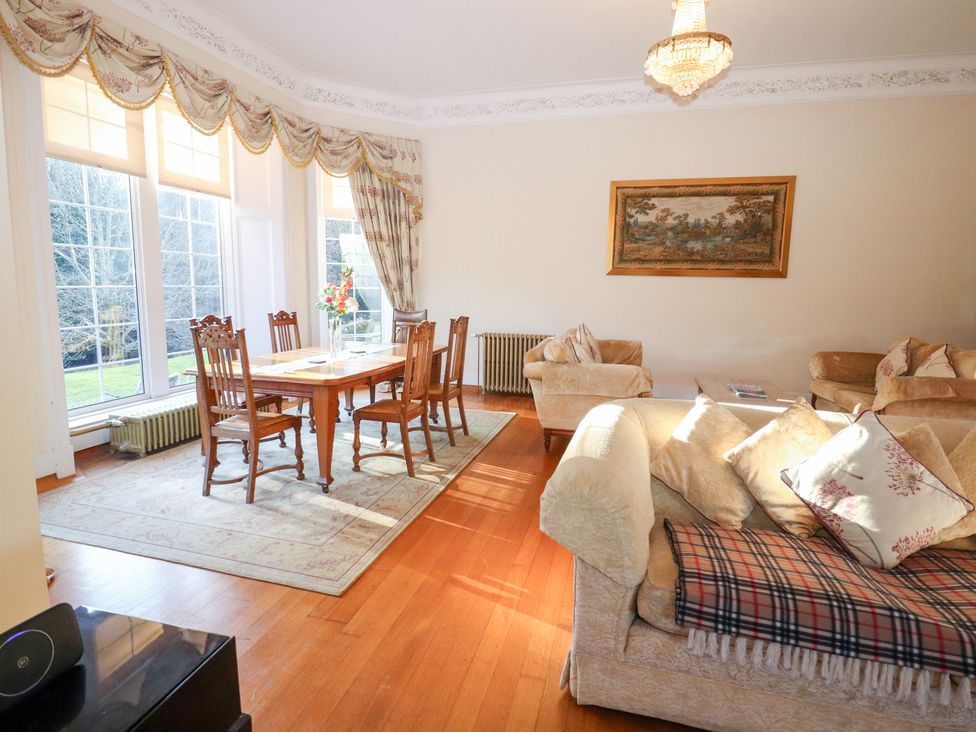 A living room with a dining table and chairs at Auchentroig House in Buchlyvie