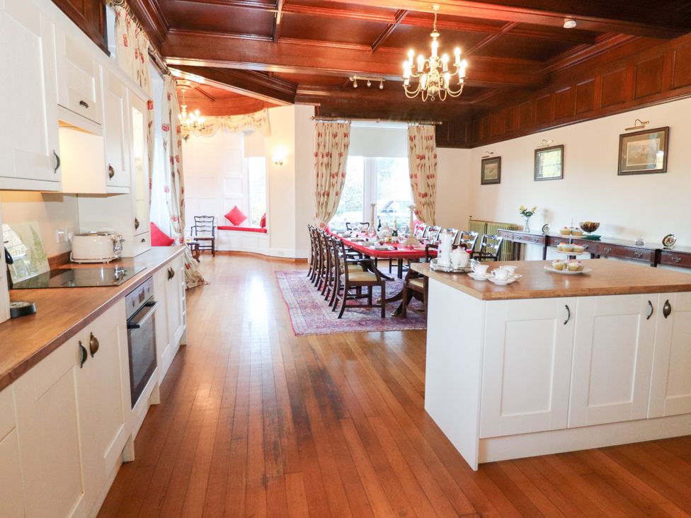 A kitchen and dining area with wooden furniture at Auchentroig House Buchlyvie