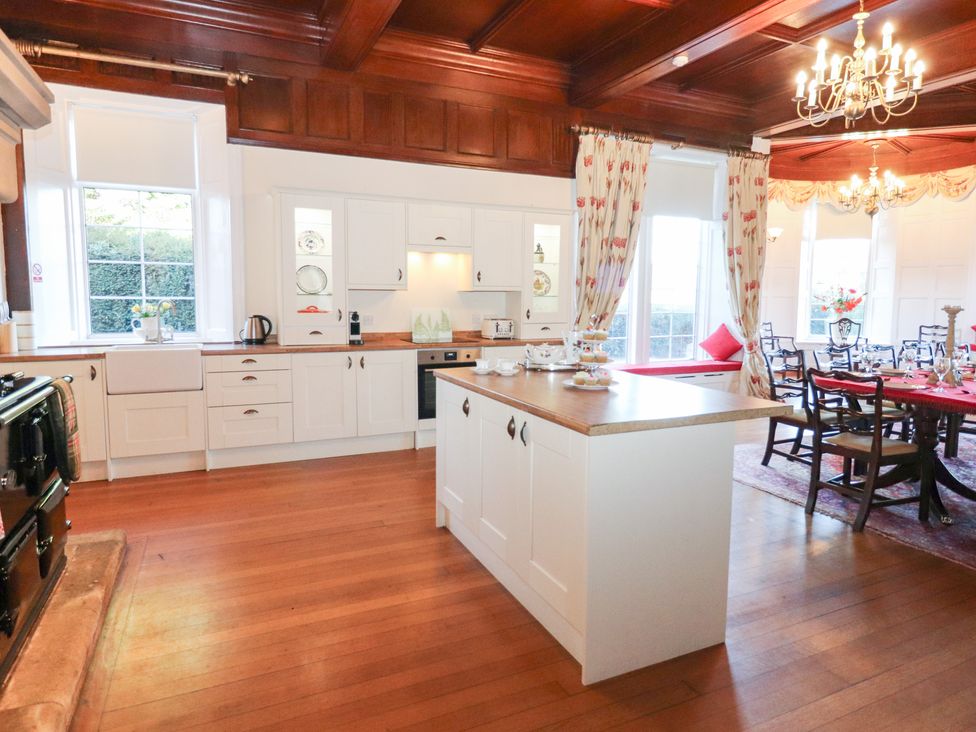 A kitchen with wooden cabinets and island at Auchentroig House in Buchlyvie