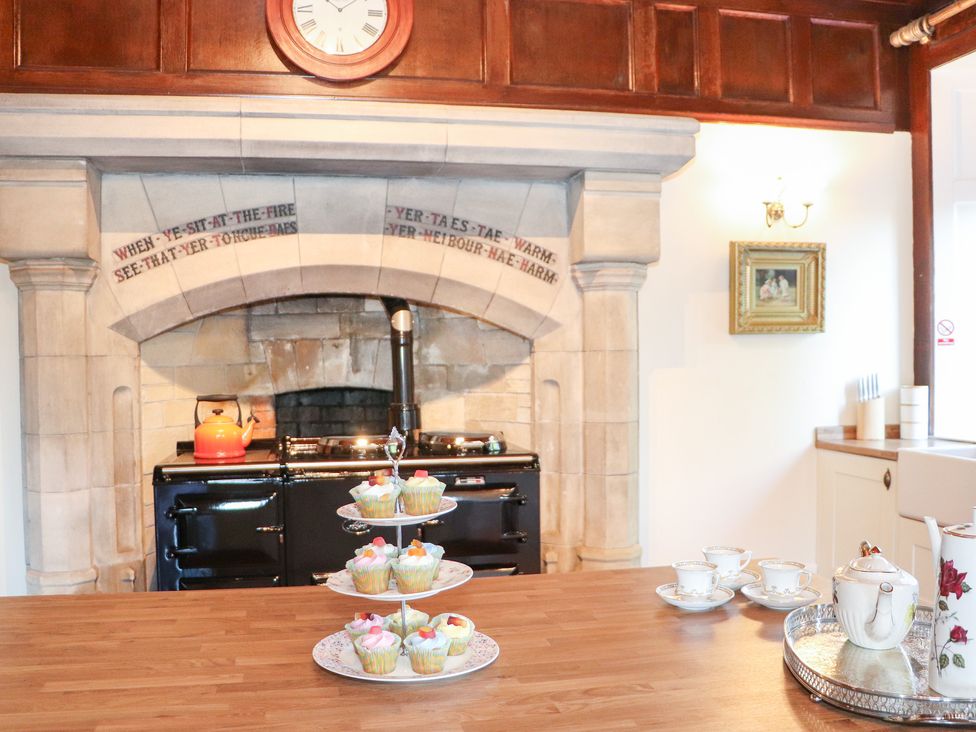 A kitchen with a stove and cupcakes on a stand at Auchentroig House in Buchlyvie
