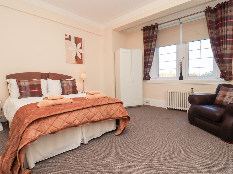 A bedroom with a bed and wardrobe at Auchentroig House Buchlyvie