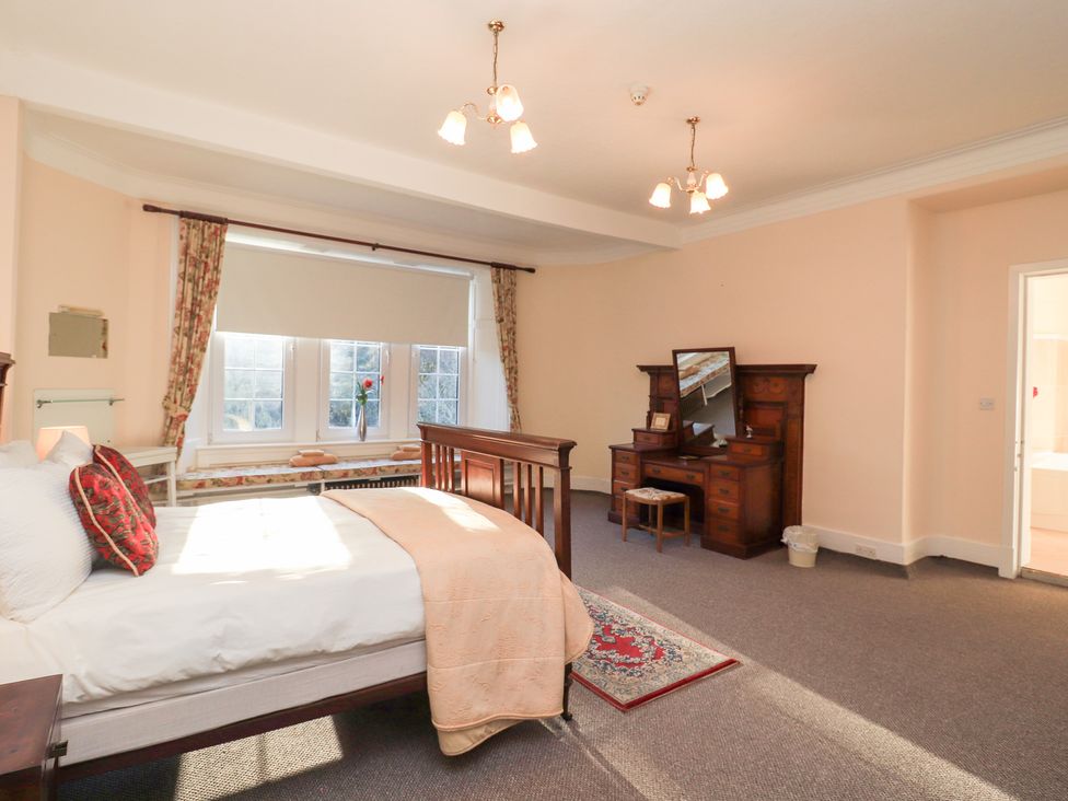 A bedroom with a bed and dressing table at Auchentroig House Buchlyvie