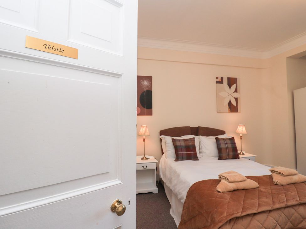 A bedroom with a bed and nightstands at Auchentroig House Buchlyvie