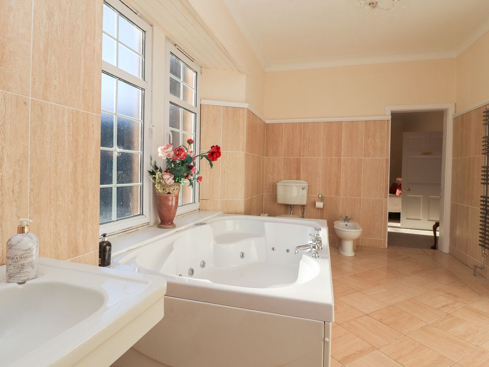 A bathroom featuring a bathtub and sink at Auchentroig House Buchlyvie