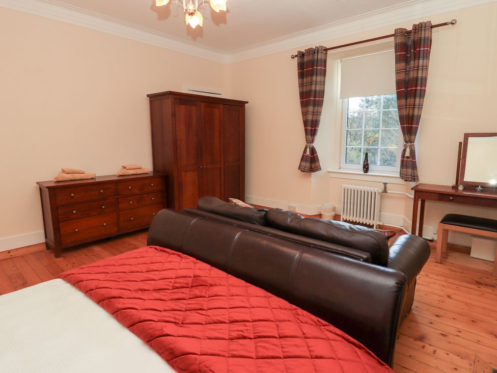 A bedroom with a bed and dresser at Auchentroig House Buchlyvie