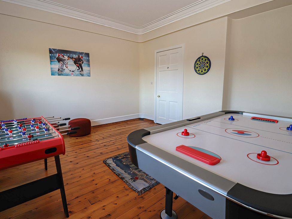 A game room with a foosball table and air hockey table at Auchentroig House Buchlyvie