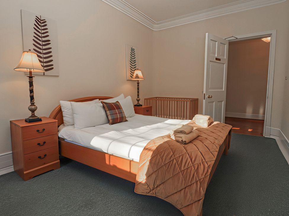 A bedroom with a bed and nightstand at Auchentroig House Buchlyvie