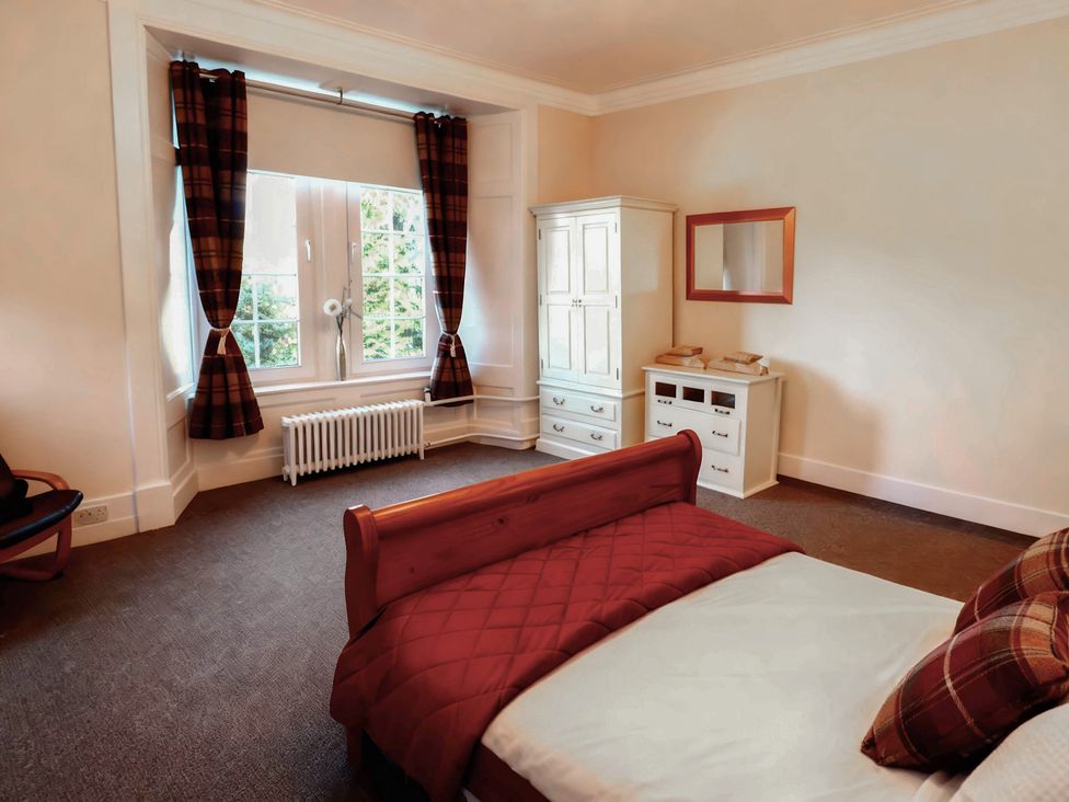 A bedroom with a bed and dresser at Auchentroig House Buchlyvie