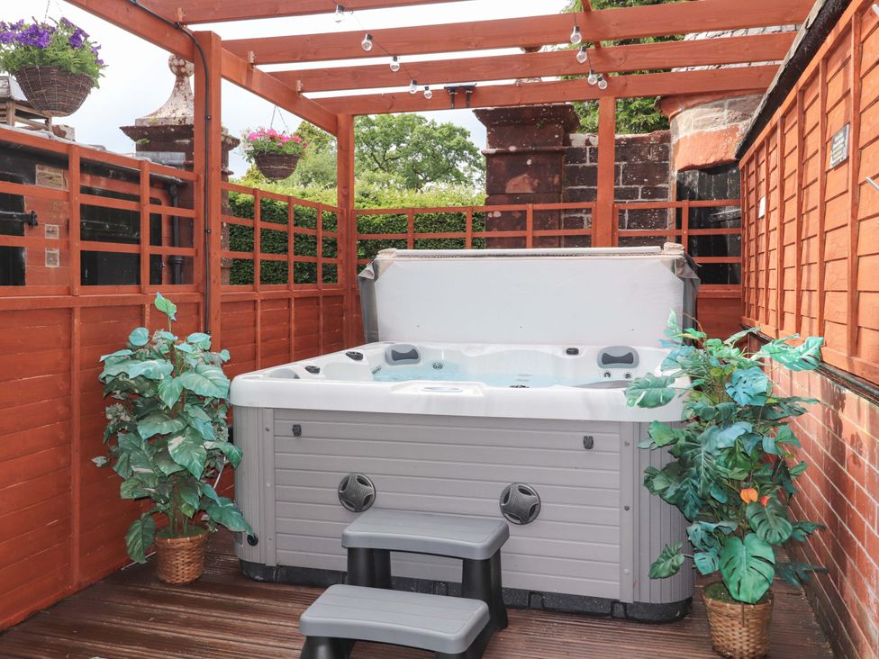 A hot tub with stairs and plants in a private garden at Rob Roy Apartment Buchlyvie