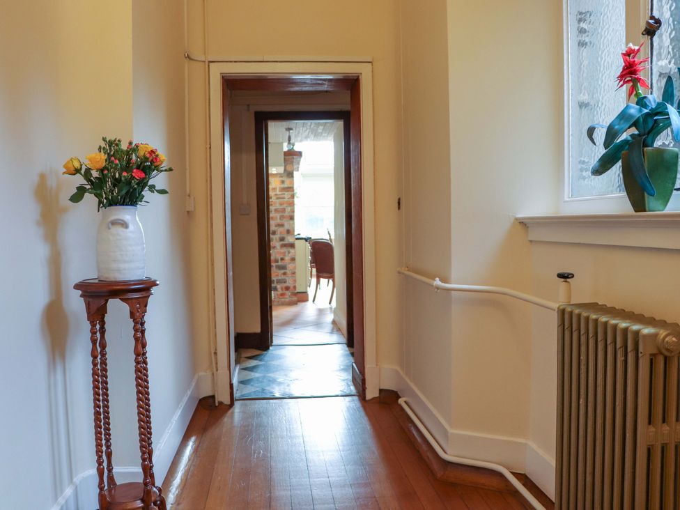 A hallway with a flower vase and a radiator at Rob Roy Apartment in Buchlyvie