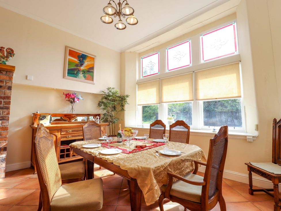 A dining room with a table and chairs at Rob Roy Apartment in Buchlyvie