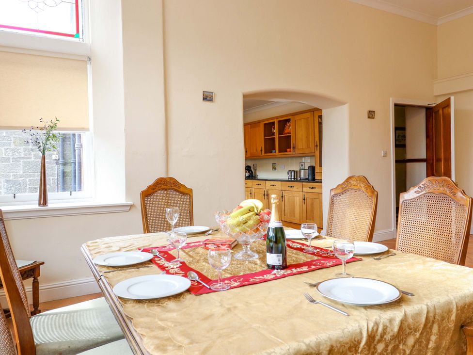 A dining room with a table set for dinner at Rob Roy Apartment in Buchlyvie