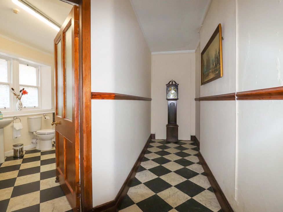 A hallway with a toilet and sink at Rob Roy Apartment in Buchlyvie