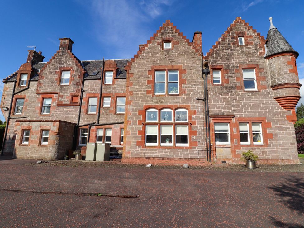 A building with windows and a parking area at Rob Roy Apartment in Buchlyvie